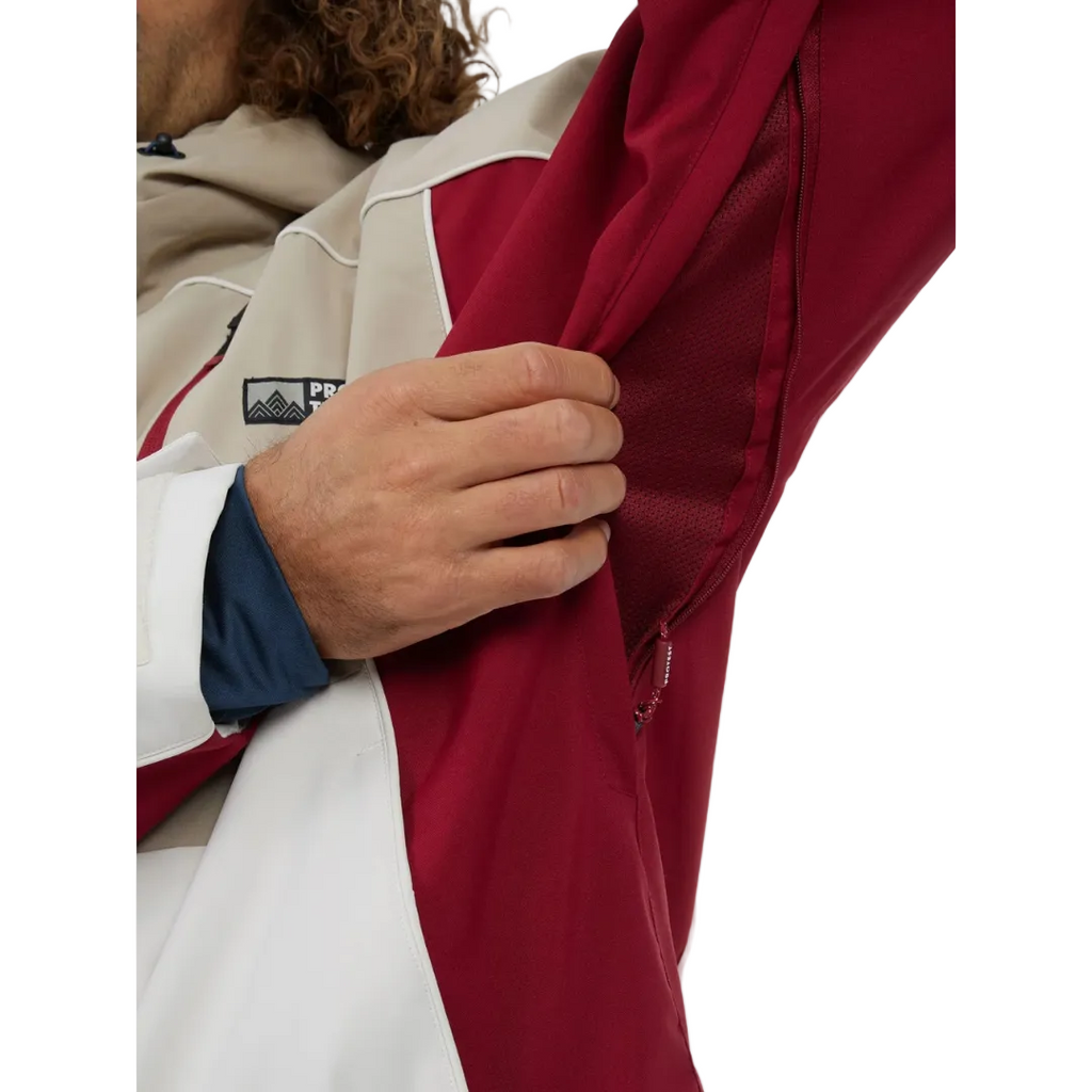 Close-up of a person wearing a red jacket with a visible brand logo on a white background